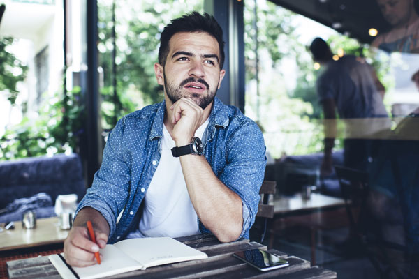 contemplative Caucasian hipster guy with notepad